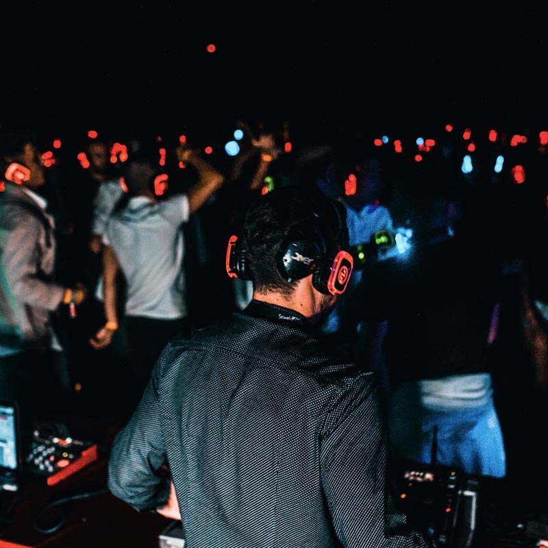 Une personne passe de la musique pendant une silent party, le public au casque