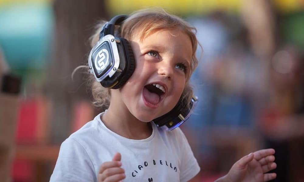 Petite fille souriante avec un casque silent party lumineux